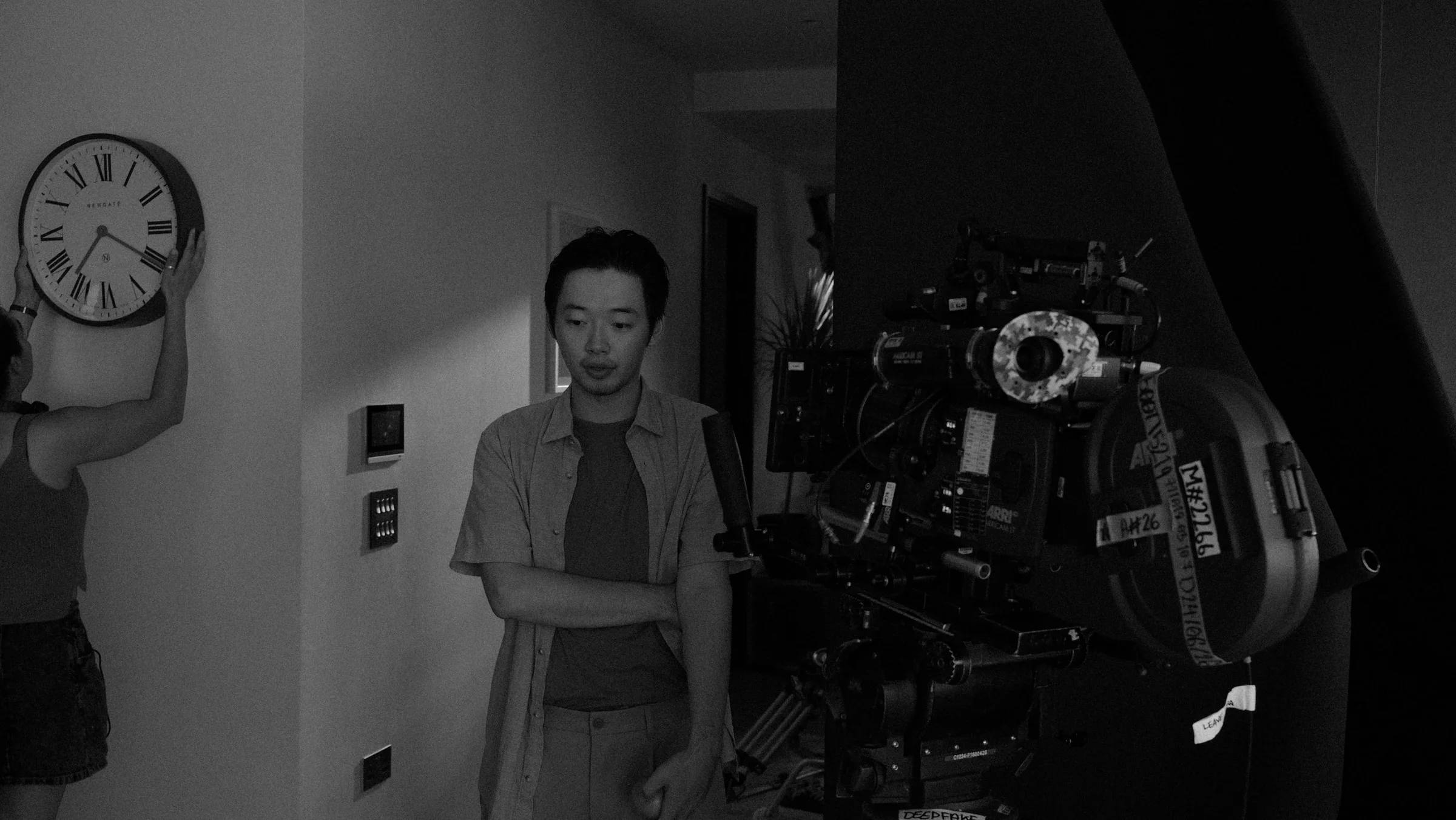 Performer standing beside a cinema camera