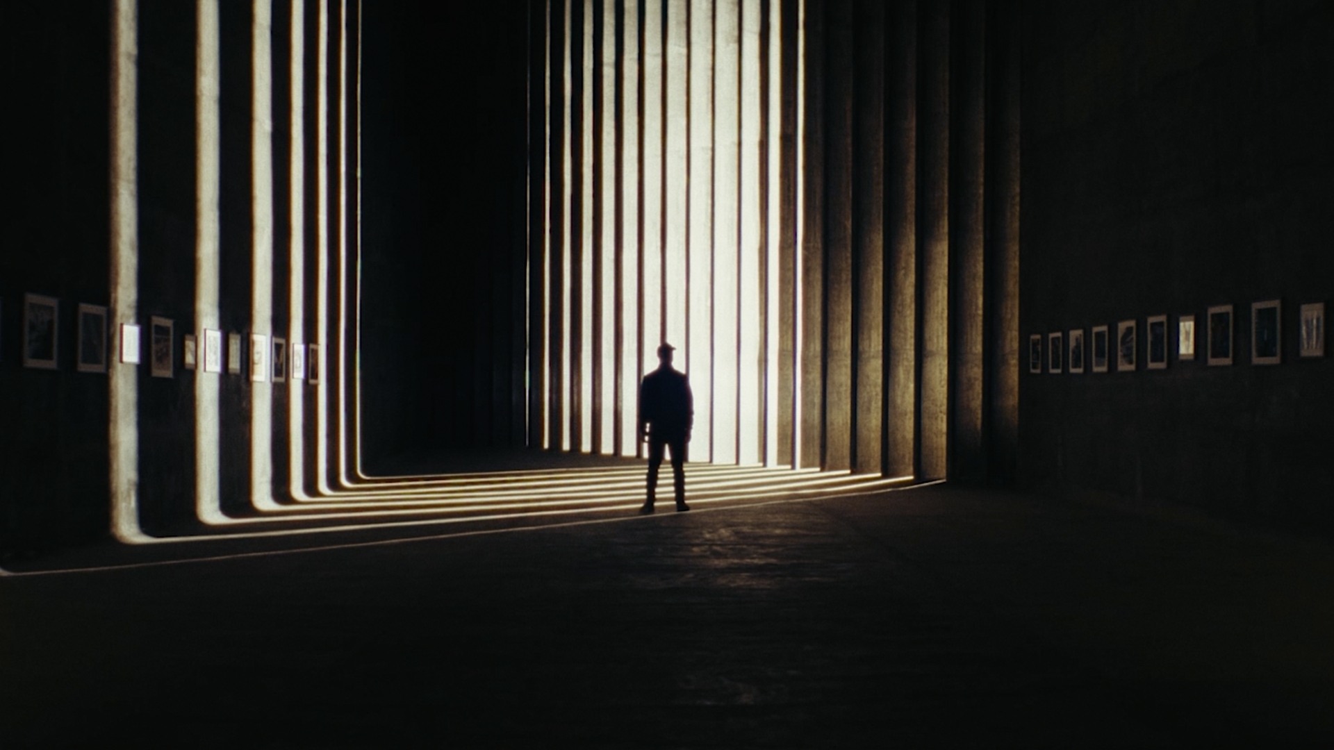 Man stood in a tunnel with pictures on the wall